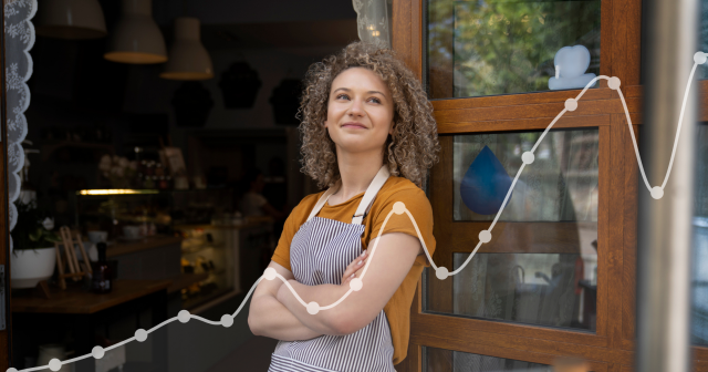 Woman business owner standing in front of door with arms crossed