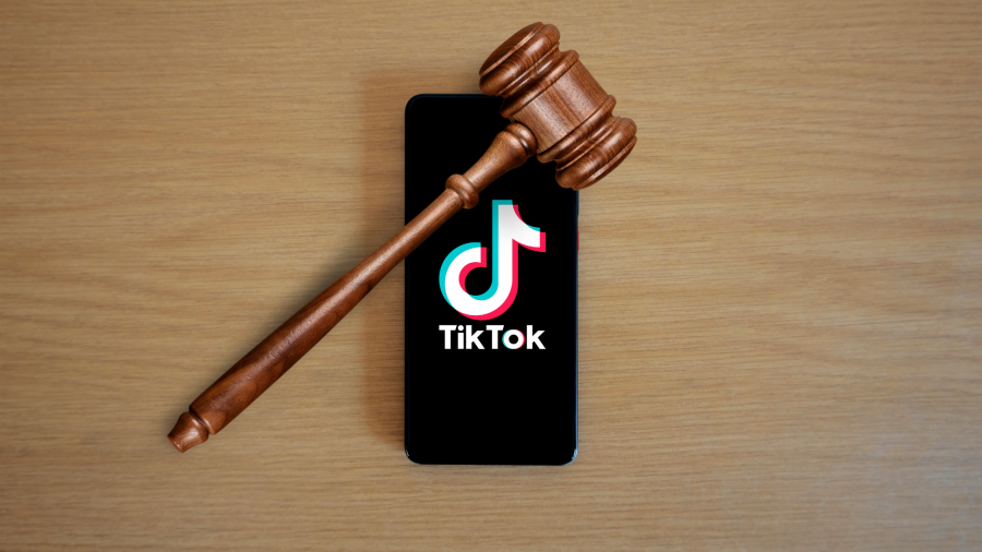 Phone on a table with the TikTok app opened and a gavel over the phone